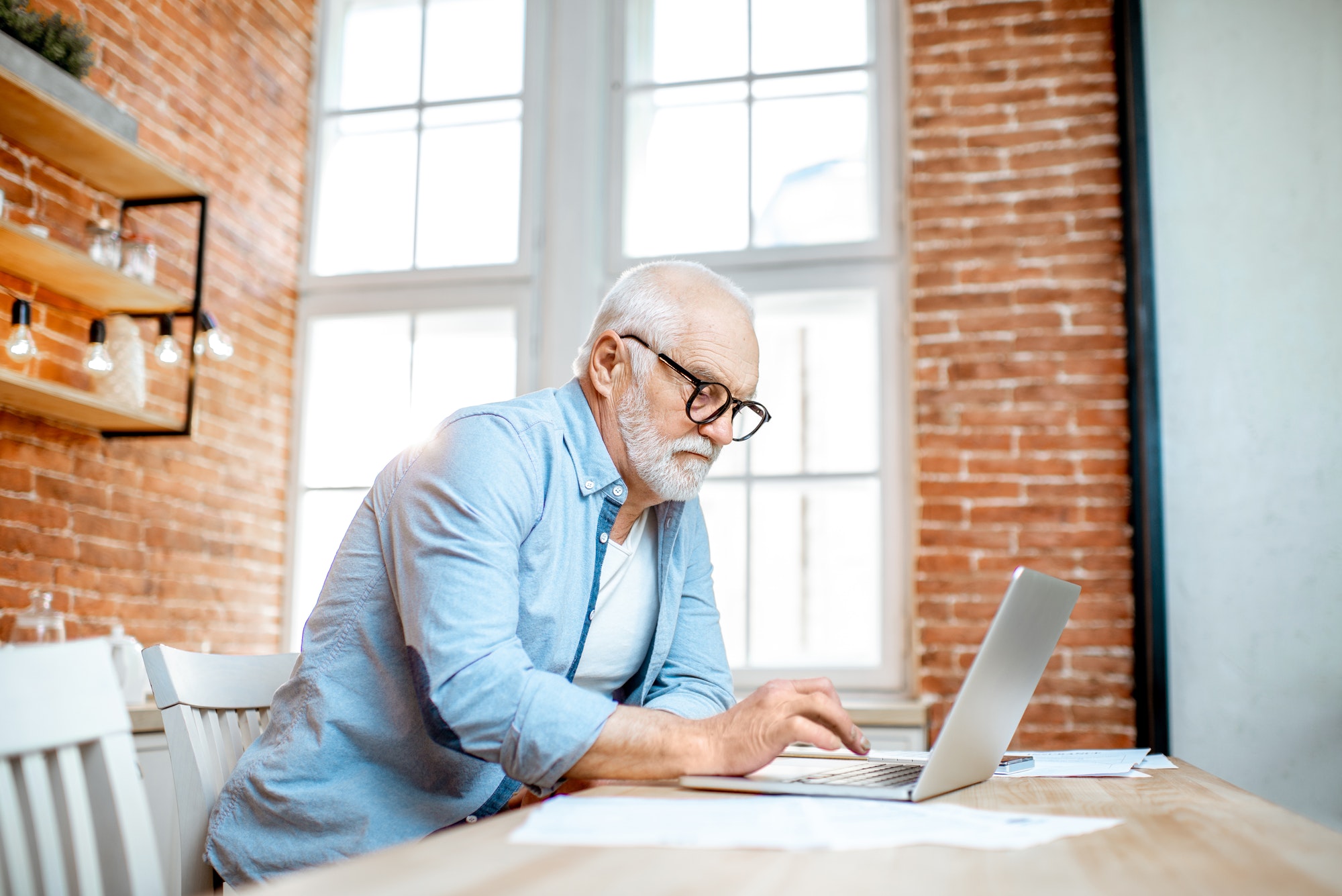 Senior man with laptop at home
